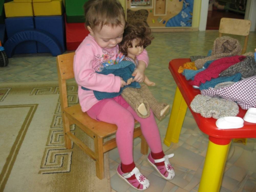 Мама собирает куклу. Дети в детском саду. Одевание в младшей группе. Куклы для детей младшей группы. Дети одеваются на прогулку в детском саду.