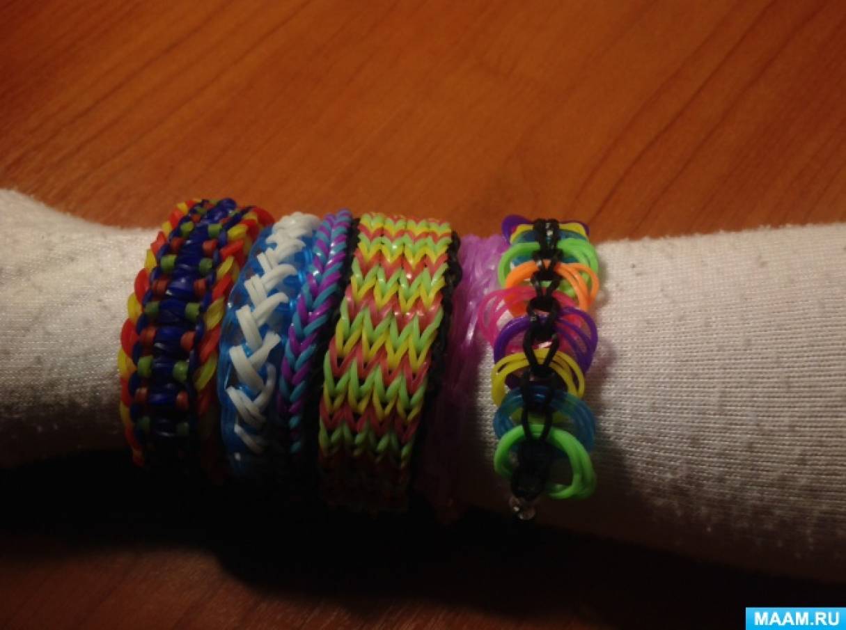 Фото №9 Теперь когда у вас образовались три ряда резинок надо снять нижний ряд те резинки которые образованы восьмеркой скидывая их поверх остальных по центру