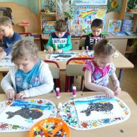 Одни ребята смазывают клеем поверхность контурного изображения